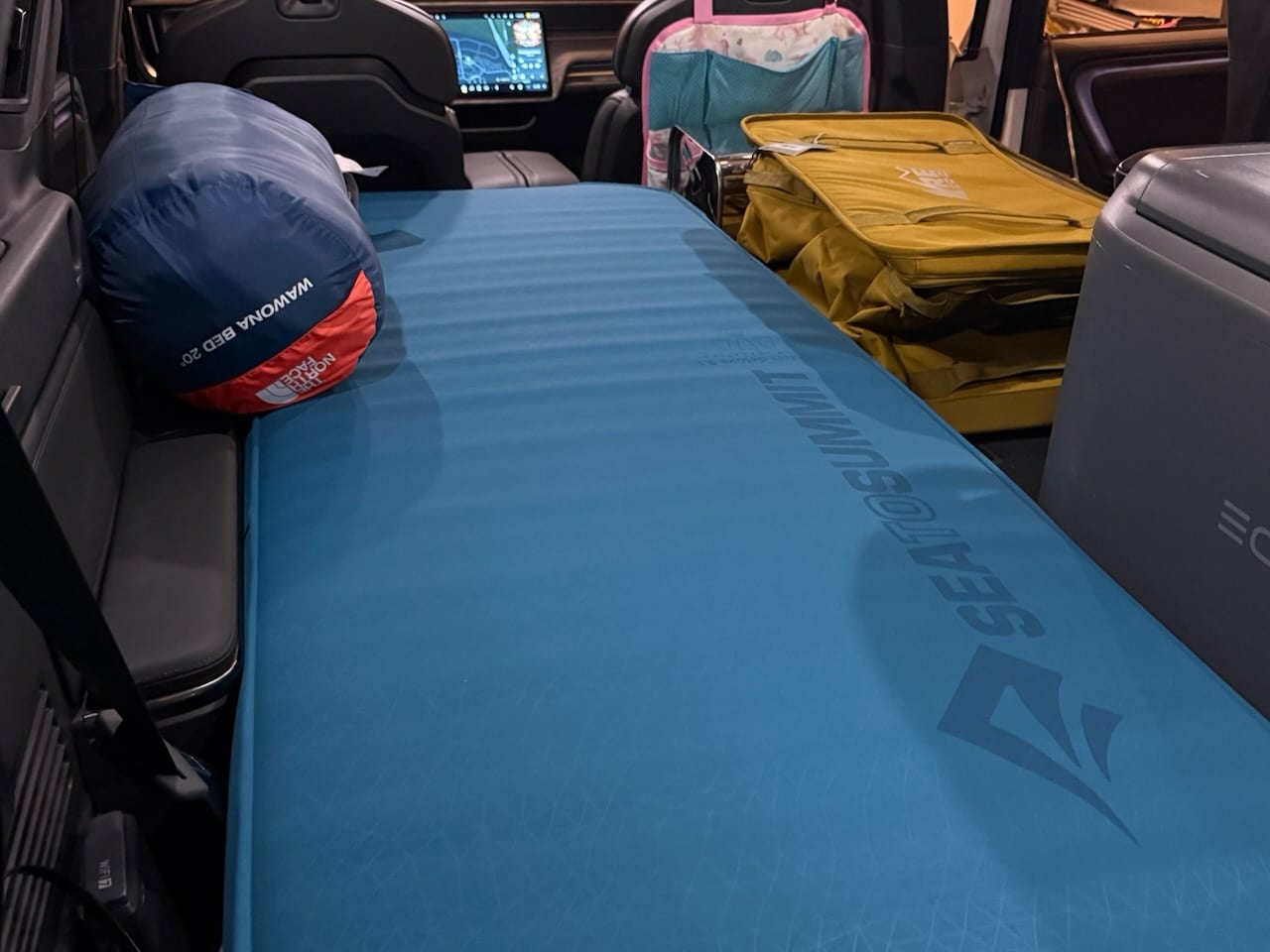 Sea to Summit mattress and a sleeping bag set up in the back of the Rivian