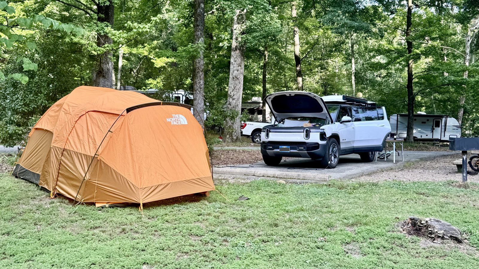 Our tent and the Rivian with its frunk open, charging off the campsite hookup at Gulpha Gorge Campground, Hot Springs