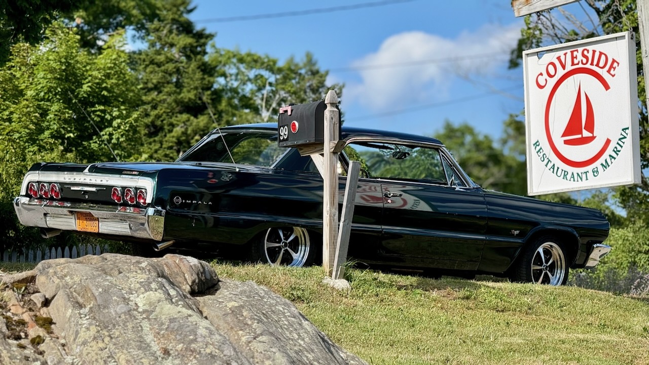 A classic Chevrolet Impala parked outside Coveside Restaurant and Marina in South Bristol, Maine