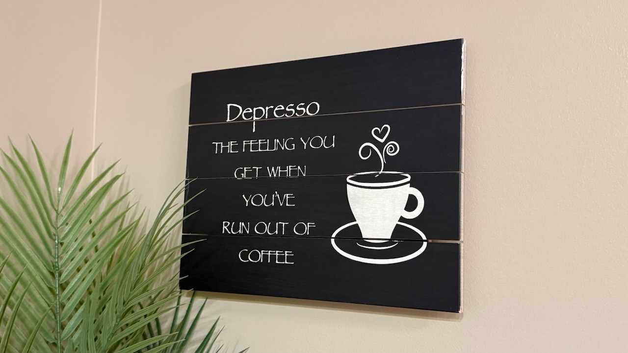 A wooden sign reading Depresso: the feeling you get when you've run out of coffee
