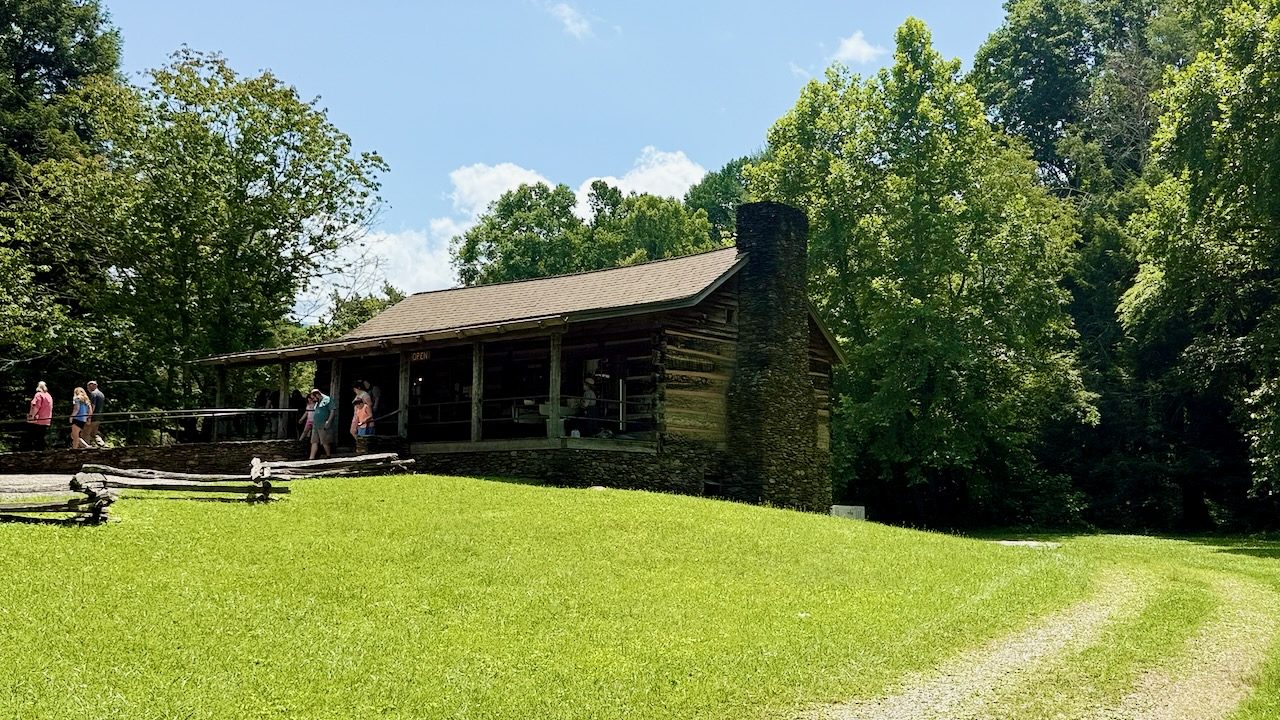 A log cabin and lawn at a historic homestead in Cades Cove